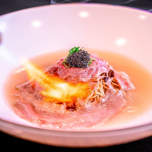 NōKA Ramen & Bar's ramen with beef, caviar, and a torch flame caramelizing the top.